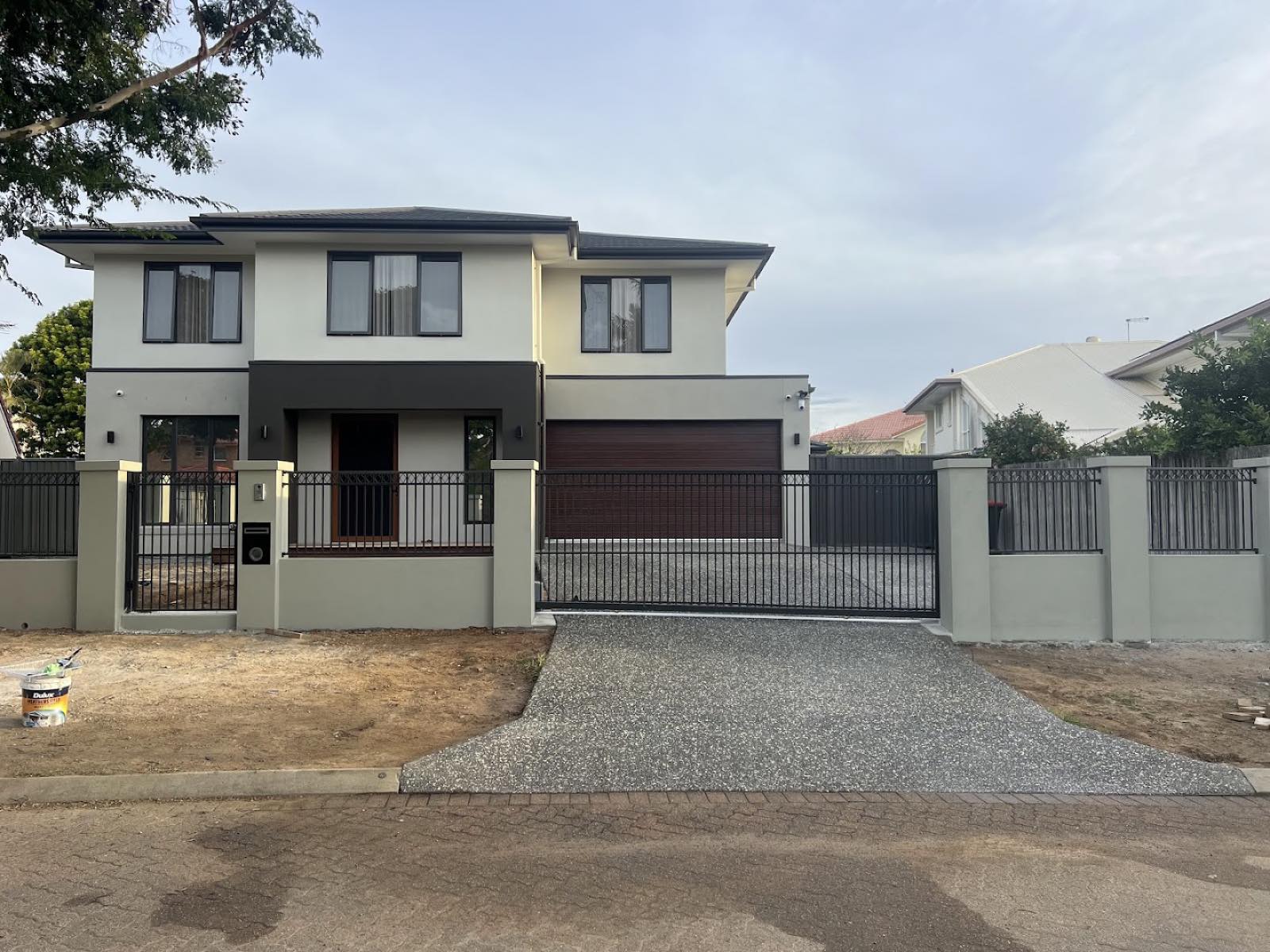 Wrought-iron front fence and automatic driveway gate on a two-storey Brisbane home
